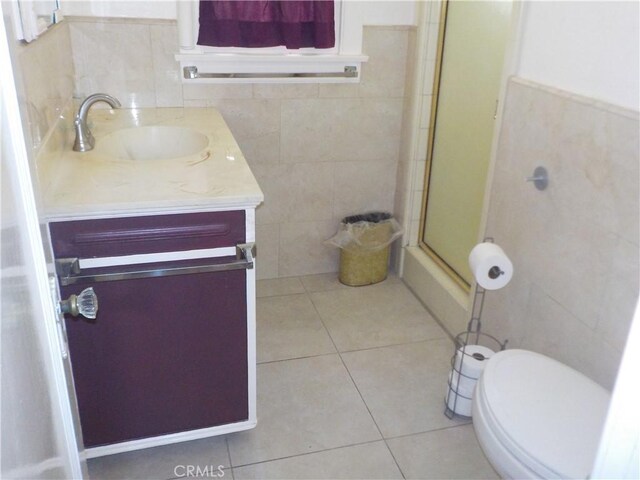 2698 Fremontia Dr, San Bernardino, CA 92404 - bathroom featuring tile walls, vanity, a shower with door, tile patterned floors, and toilet