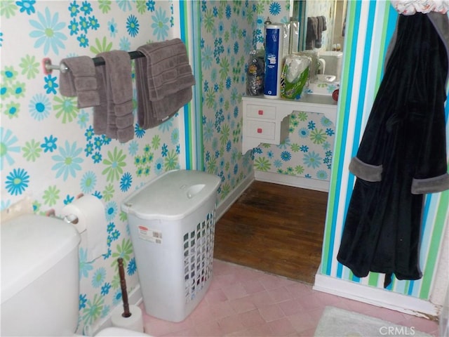 2698 Fremontia Dr, San Bernardino, CA 92404 - bathroom with wallpapered walls, baseboards, toilet, and wood finished floors