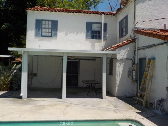 2698 Fremontia Dr, San Bernardino, CA 92404 - rear view of house featuring a tile roof, stucco siding, a patio area, an outdoor pool, and a ceiling fan