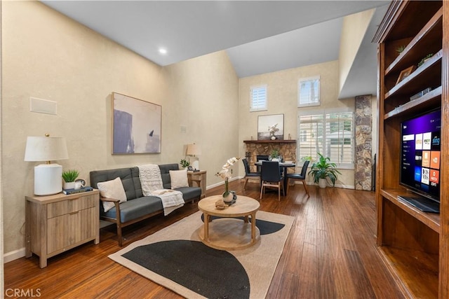 11034 Creekbridge Pl, San Diego, CA 92128 - living area with hardwood / wood-style floors, a stone fireplace, baseboards, and a towering ceiling