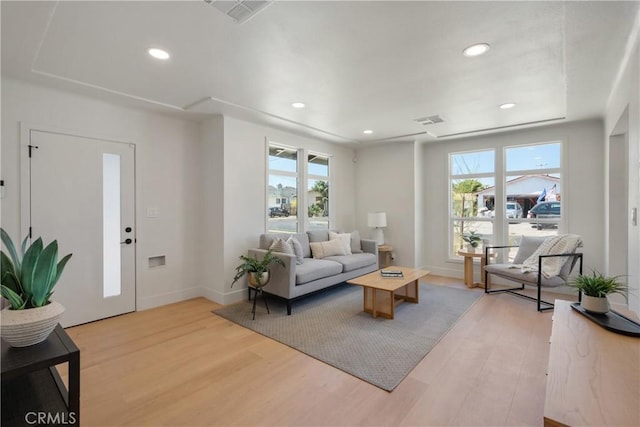 living room featuring plenty of natural light, light wood-style floors, recessed lighting, and baseboards