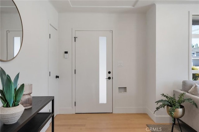 foyer entrance featuring light wood-style floors and baseboards