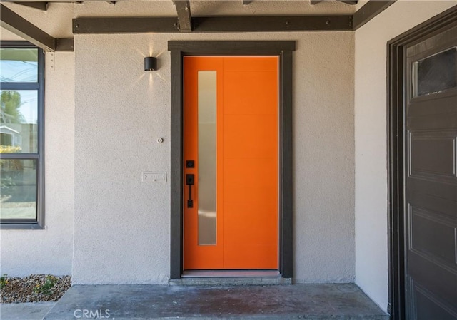 view of exterior entry featuring stucco siding and elevator