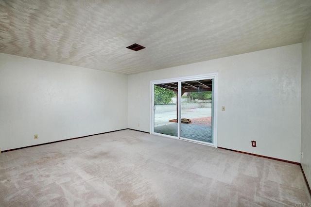 unfurnished room with baseboards, carpet, and a textured ceiling