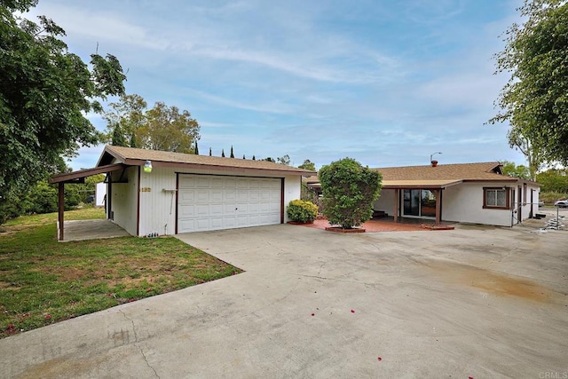 single story home featuring a front yard and a detached garage