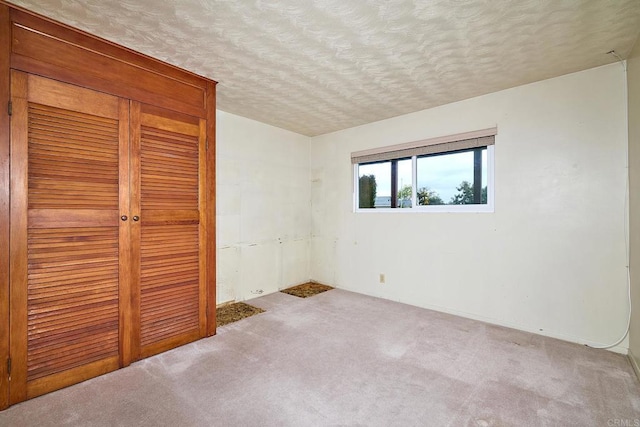 unfurnished bedroom featuring a closet, carpet floors, and a textured ceiling