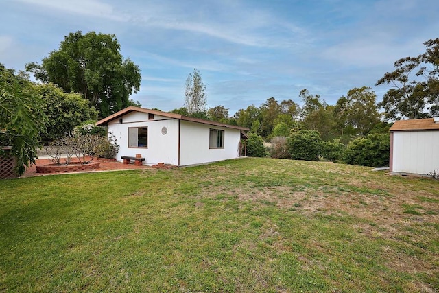 view of green lawn featuring an outbuilding