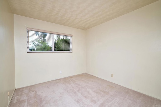 unfurnished room with carpet and baseboards