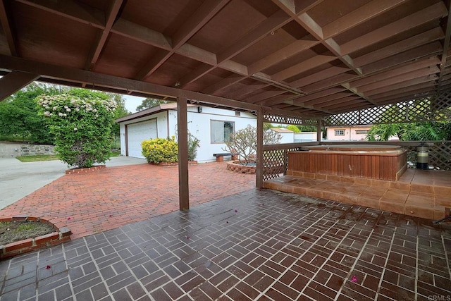 view of patio / terrace featuring an outdoor hot tub, an outdoor structure, and a detached garage