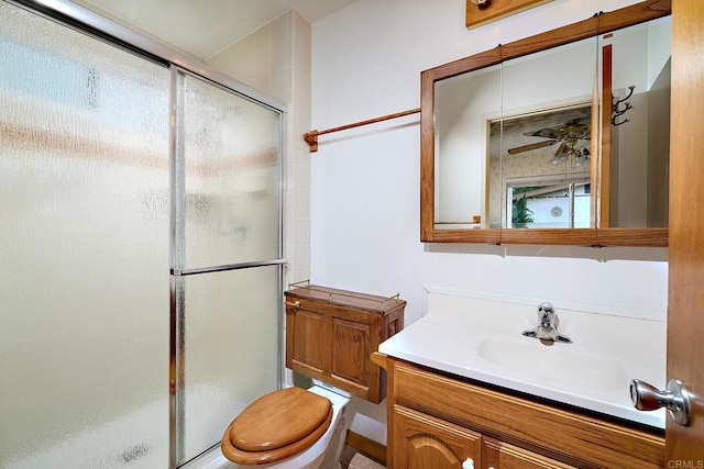 bathroom featuring a shower stall, vanity, and toilet
