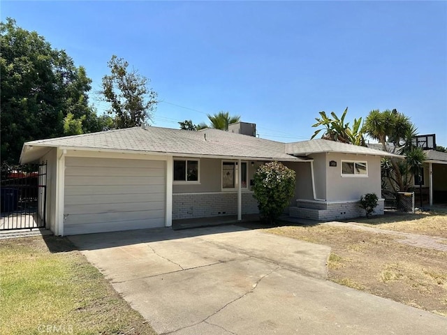 1950 E Simpson Ave, Fresno, CA 93703 - ranch-style house with a garage, brick siding, driveway, and fence