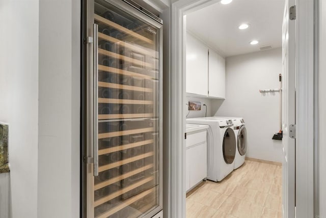 clothes washing area with beverage cooler, cabinet space, independent washer and dryer, recessed lighting, and light tile patterned floors