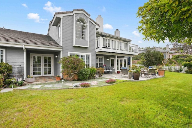 rear view of property featuring french doors, a patio, and a chimney