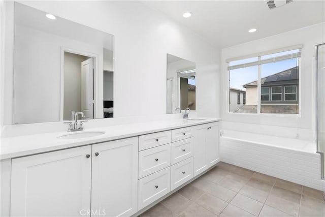 bathroom with double vanity, a tub, recessed lighting, and tile patterned flooring