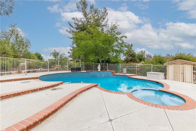 view of swimming pool with a patio, fence, and a pool with connected hot tub