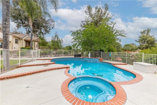 view of swimming pool with a pool with connected hot tub, fence, and a patio area