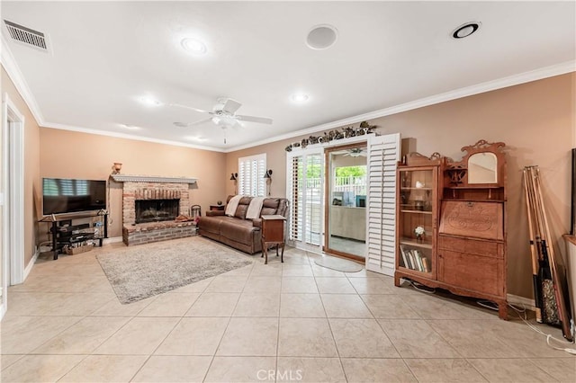 living area featuring a ceiling fan, crown molding, a fireplace, light tile patterned flooring, and baseboards