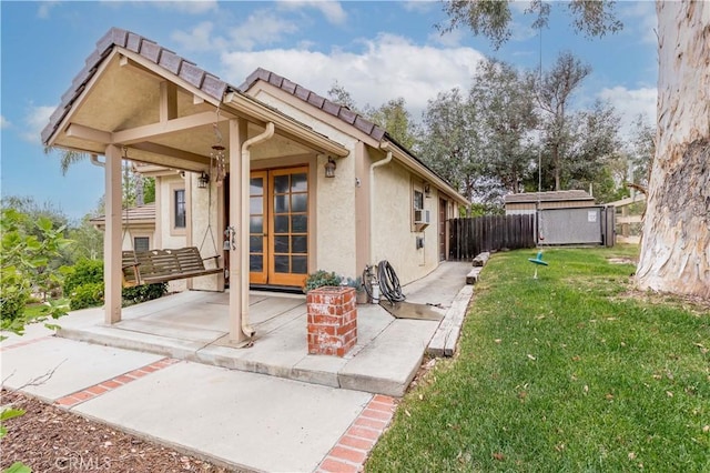 entrance to property with stucco siding, a patio, a tiled roof, and cooling unit
