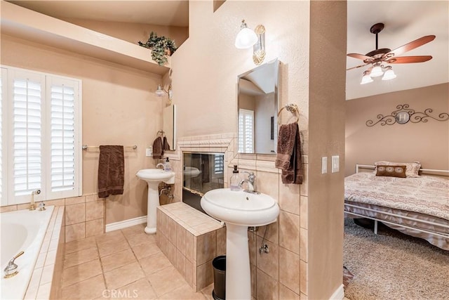 full bathroom with ceiling fan, a bath, a tile fireplace, and tile patterned flooring