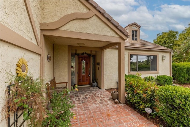 entrance to property featuring stucco siding