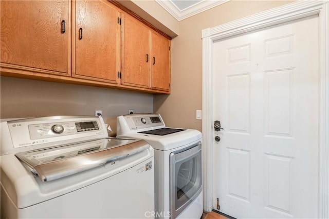 laundry area featuring washing machine and clothes dryer, cabinet space, and ornamental molding