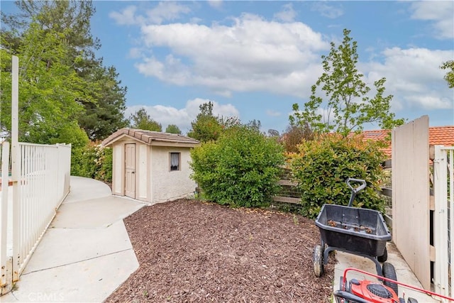 view of yard with fence, an outbuilding, and a storage shed
