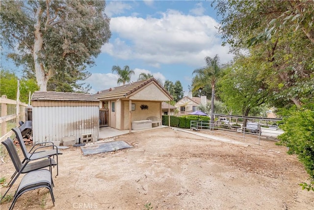 back of property with an outbuilding, a storage shed, and fence
