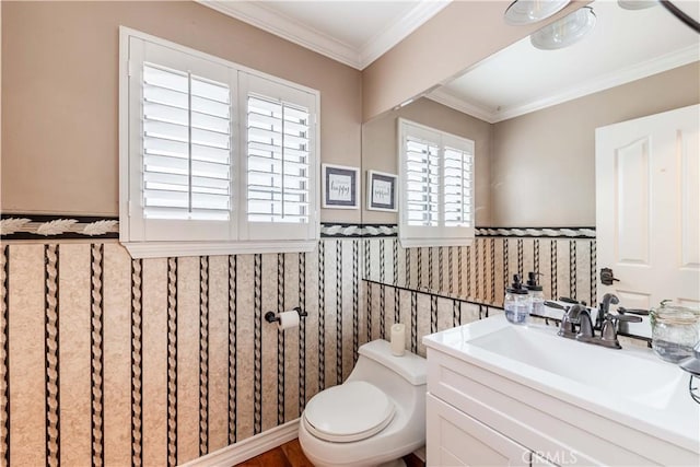 half bath featuring wainscoting, toilet, ornamental molding, and vanity