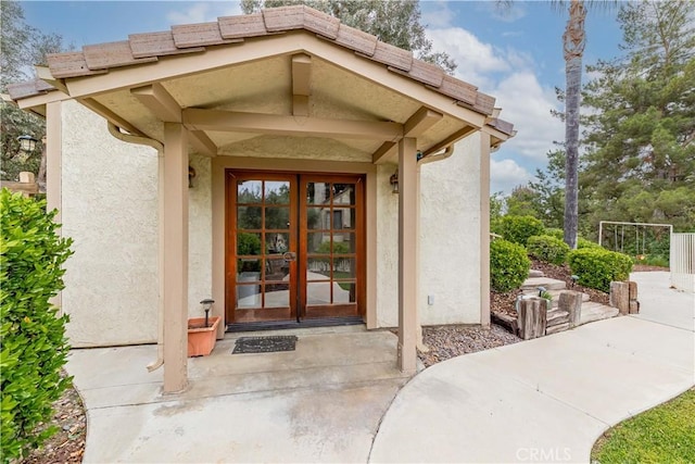 entrance to property with french doors and stucco siding