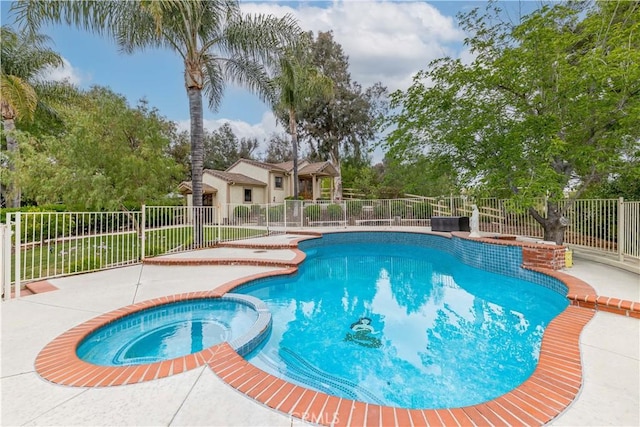 view of pool featuring a pool with connected hot tub, fence, and a patio