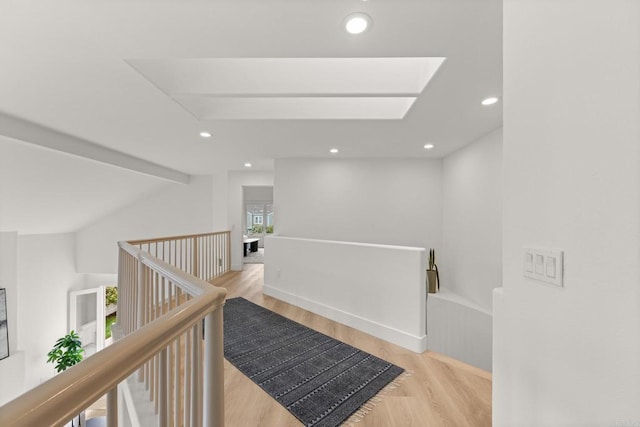 hall featuring an upstairs landing, wood finished floors, and recessed lighting