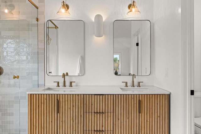 bathroom featuring a stall shower, double vanity, and toilet
