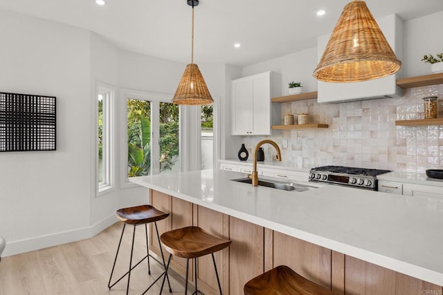 kitchen featuring open shelves, a sink, stove, decorative backsplash, and recessed lighting