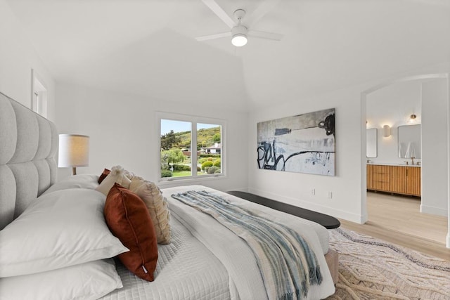 bedroom with light wood-style flooring, ensuite bathroom, a ceiling fan, baseboards, and lofted ceiling
