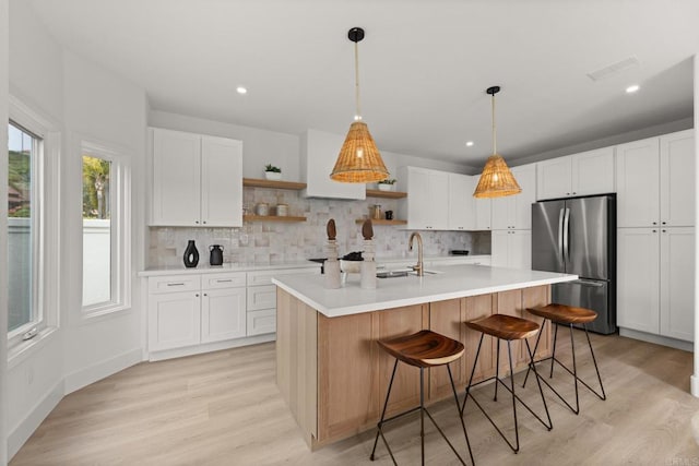 kitchen featuring freestanding refrigerator, open shelves, tasteful backsplash, light countertops, and recessed lighting