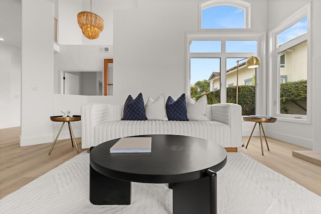 sitting room featuring wood finished floors, baseboards, and a towering ceiling