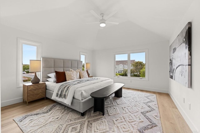 bedroom with multiple windows, lofted ceiling, baseboards, wood finished floors, and ceiling fan