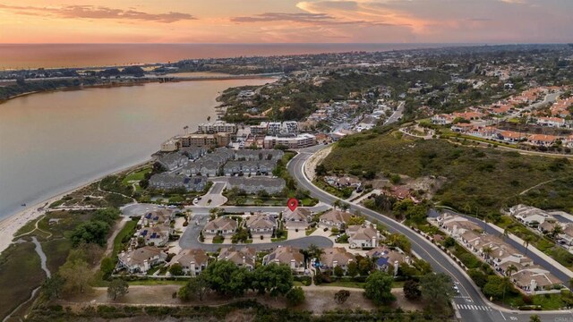 aerial view of property's location featuring a large body of water and nearby suburban area