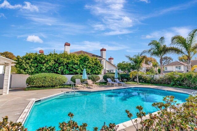 view of swimming pool featuring fence and a patio area