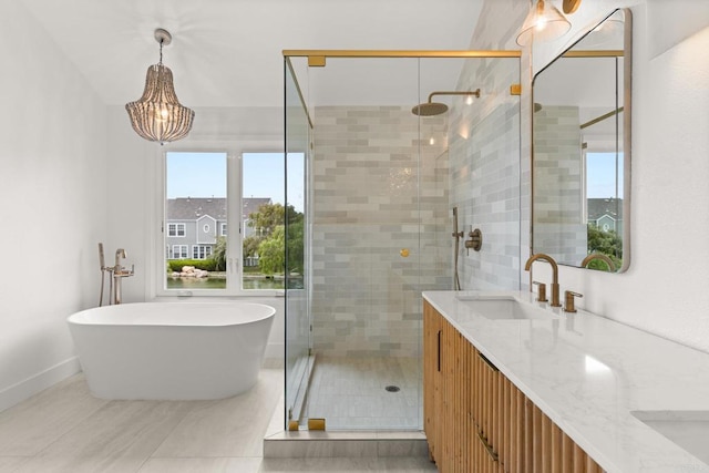 bathroom with a stall shower, vanity, a freestanding bath, and baseboards
