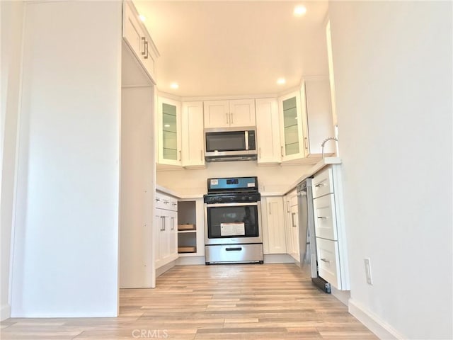 14253 Gilmore St Unit A, Van Nuys, CA 91401 - kitchen with stainless steel appliances, light wood-type flooring, light countertops, recessed lighting, and glass insert cabinets