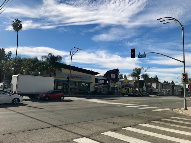 14253 Gilmore St Unit A, Van Nuys, CA 91401 - view of asphalt street with traffic lights, sidewalks, street lights, and curbs