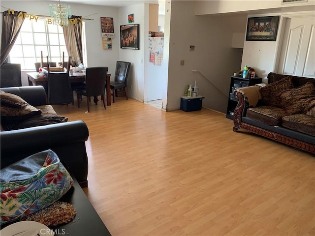 14253 Gilmore St Unit A, Van Nuys, CA 91401 - living area featuring light wood finished floors, a chandelier, and baseboards