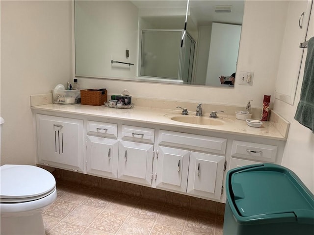 bathroom featuring a stall shower, vanity, toilet, and tile patterned flooring
