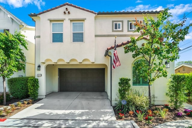 mediterranean / spanish-style house with stucco siding, a garage, and driveway
