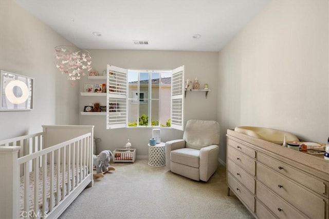 bedroom with light carpet and a nursery area