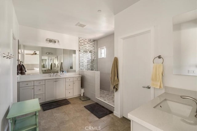 bathroom featuring two vanities, walk in shower, and a ceiling fan