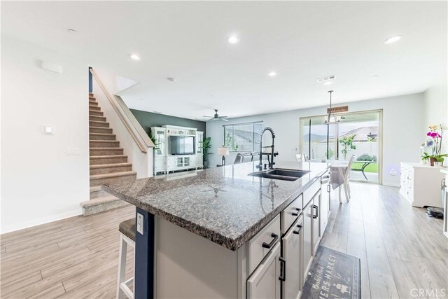 29652 Falcon Hill Dr, Menifee, CA 92584 - kitchen with a sink, light wood-type flooring, an island with sink, baseboards, and recessed lighting