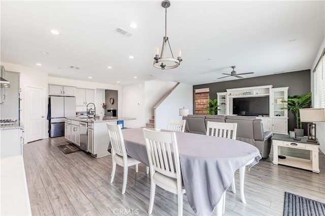 29652 Falcon Hill Dr, Menifee, CA 92584 - dining area with stairs, ceiling fan, light wood-style flooring, a chandelier, and recessed lighting