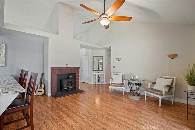 9 Benton Ave, Chico, CA 95973 - living room with a wood stove, ceiling fan, wood finished floors, baseboards, and a high ceiling